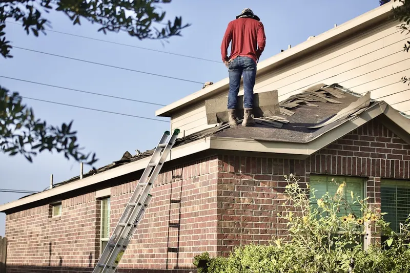 Professional roofer working on a residential roof in Climax